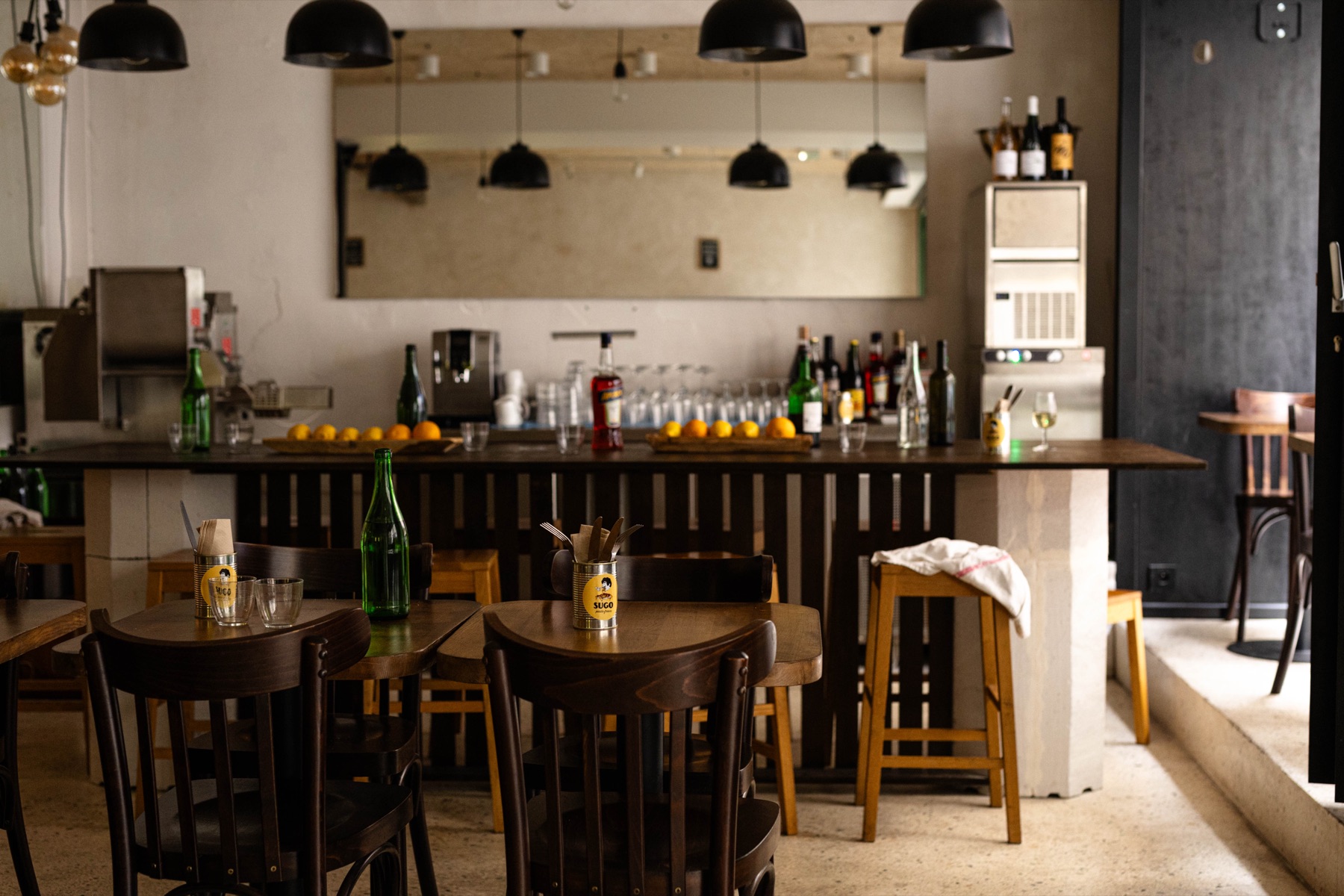La salle de SUGO Saint-Augustin, carrelage jaune et tables en bois